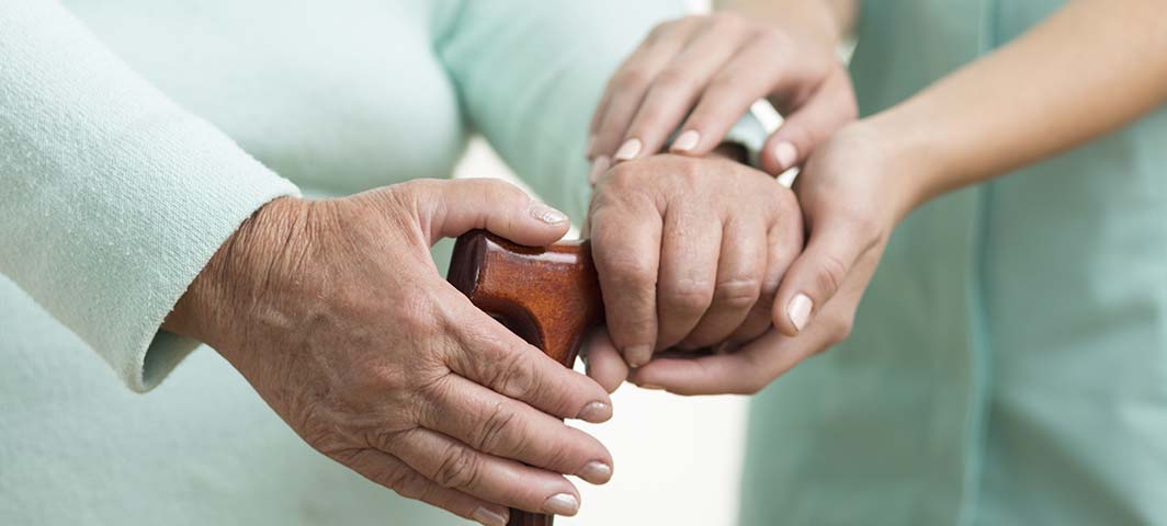 une personne agée en sécurité avec une soignante qui veille sur elle